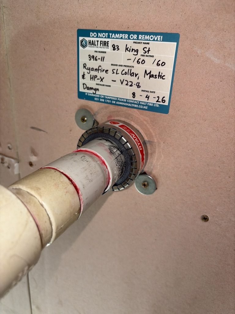 Intumescent fire collar on a PVC pipe through a fire-rated ceiling