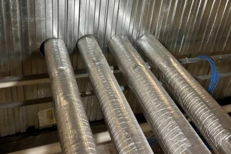 Four insulated copper pipes passing through unsealed openings in a KOROK panel fire wall at Anglesea Day Procedure, Hamilton, before fire stopping